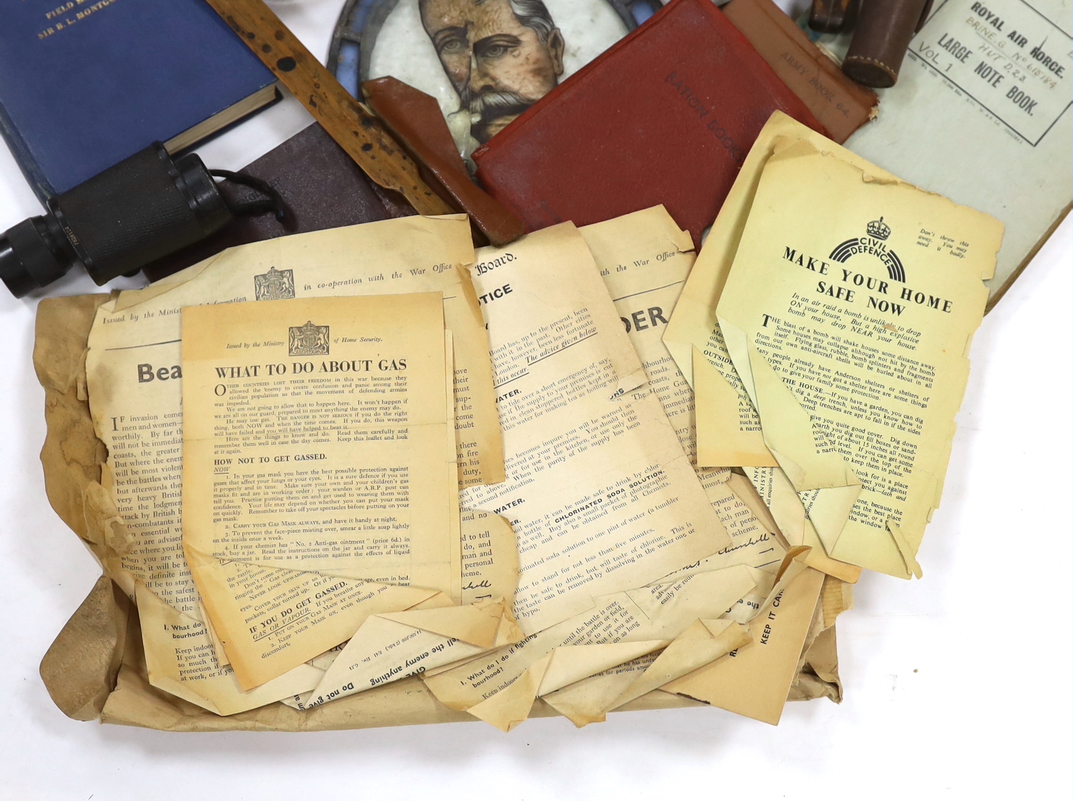 A collection of militaria, including a brass model of a Napoleonic era field gun, a stained glass panel, a Royal Air Force notebook, Civil Defence leaflets, etc.